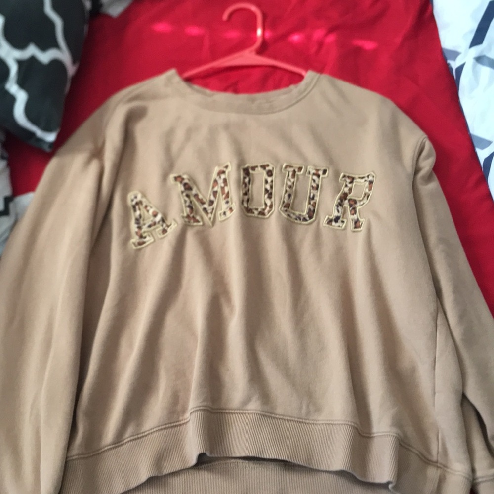 A nude colored shirt with the word “AMOUR”